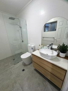 a bathroom with a sink and a toilet and a mirror at Oceanside Cove in Gold Coast