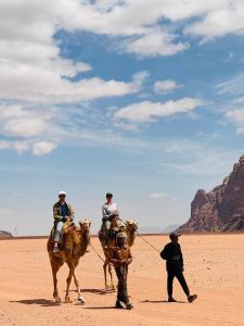 a group of people riding horses in the desert at Rum Sky Experiences in Wadi Rum