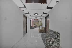 a hallway with chairs in a building with white walls at Hotel O Rudra Palace in Ahmedabad