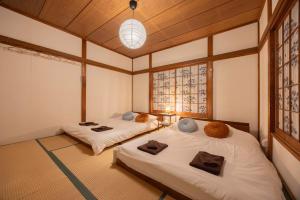 zwei Betten in einem Zimmer mit zwei Fenstern in der Unterkunft Lido Urayasu in Tokio