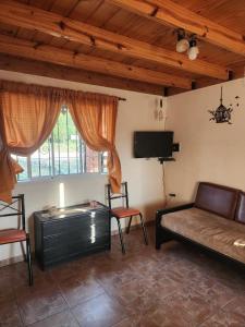 a living room with a couch and a flat screen tv at Cabañas Dulce Atardecer in Villa Carlos Paz