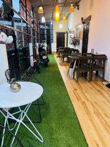 a room with tables and chairs and a green rug at AHK Homestay 1 in Phu Quoc