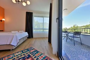 a hotel room with a bed and a balcony at Begonvilla Göcek Gökceovacik in Fethiye