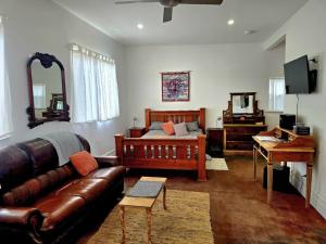 a living room with a couch and a bed and a piano at Contemporary Studio Accommodation in Farrell Flat