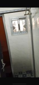 twee ramen op een witte muur met een deur bij Résidence REHA in Bafoussam +3 foto's