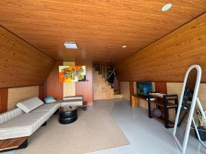 Una sala de estar con un sofá y un techo de madera. en Casa Sundara, en Patjung