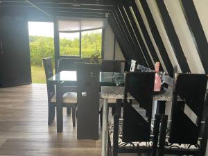 a dining room with a glass table and chairs at Cabaña alpina Júpiter in Armenia