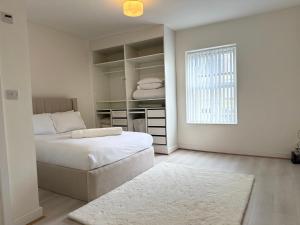 une chambre blanche avec un lit et une fenêtre dans l'établissement The Beige House, à Batley