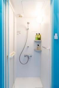 een douche in een badkamer met een slang aan de muur bij Oyado danran 団欒 in Tokyo +29 foto's