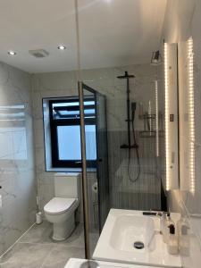 a bathroom with a toilet and a sink and a window at Two double bedroom self contained Retreat in Thundersley +35 photos