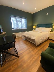 a bedroom with a bed and a desk and a chair at Two double bedroom self contained Retreat in Thundersley