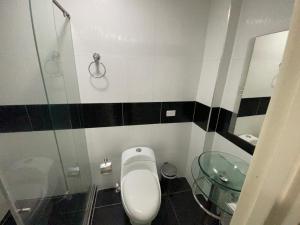 a bathroom with a toilet and a glass sink at Hotel Avei Suites in Cali