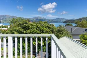 a white fence with a view of the water at Le Solterre - Akaroa Holiday Home in Akaroa