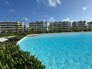 a large swimming pool in front of apartment buildings at Crystal Lagoon White Sands Beach in Punta Cana