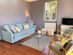 a living room with a blue couch and a table at Villa Dora Attica in Locarno