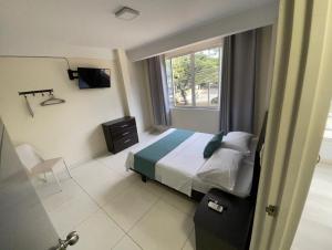 a hotel room with a bed and a window at Hotel Avei Suites in Cali