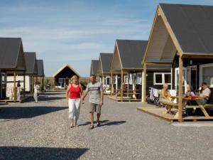 Thyborønにある4 star holiday home in Thyborønの家々が並ぶ通りを歩く男女