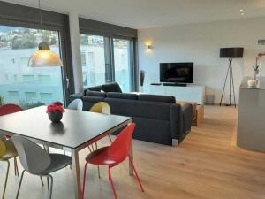 a living room with a couch and a table and chairs at 1-bedroom holiday apartment in Ascona