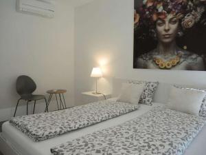 a bedroom with a bed with a painting of a woman at 1-bedroom holiday apartment in Ascona +31 photos