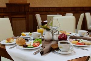 a table with plates of food and cups of coffee at David Boutique Hotel in Krakow