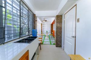 a kitchen with white counters and windows and a hallway at Ideal place to stay for 8-12pax with Parking Area in Mactan Island