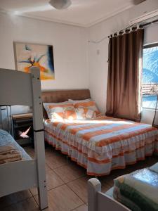 Un dormitorio con dos literas y una ventana. en Edicula com um quarto banheiro e piscina e lazer, en Foz do Iguaçu 20 fotos más