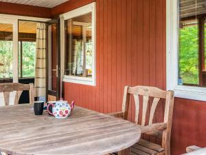 a wooden table with a cup on top of it at 4 person holiday home in R m in Mølby +13 photos