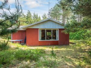 a small red house in the middle of a field at 4 person holiday home in R m in Mølby
