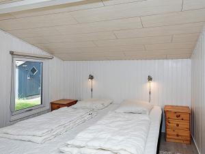 a white bedroom with two beds and a window at 4 person holiday home in Thisted in Thisted