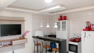 a kitchen with a counter with stools in it at Pôr do sol beach house in Porto Seguro