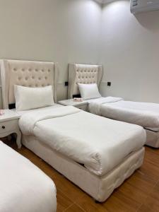 three beds are lined up in a room at فيلا فيو السلطان in Abha +37 photos