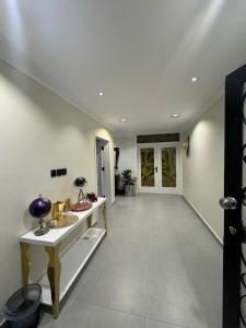 a hallway of a house with white walls and a door at فيلا فيو السلطان in Abha