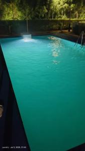 a swimming pool with blue water in a yard at Rocopie farm in Rohtak