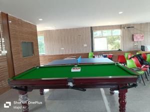a pool table in a room withroups of chairs at Rocopie farm in Rohtak