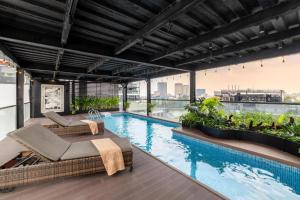 a swimming pool with two chaise lounges next to a building at Splendid Hotel & Spa in Hanoi