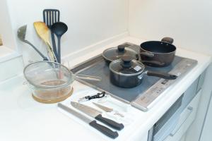a kitchen counter with pots and pans on a stove at Soshigaya Apartment by Tranova in Kamatachō