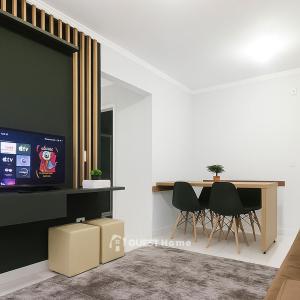 a living room with a tv and a table and chairs at Apartamento em Condomínio - 2 Dormitórios in Camboriú