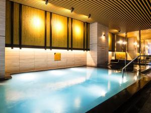 a swimming pool with blue water in a building at APA Hotel & Resort Osaka Namba Ekimae Tower in Osaka