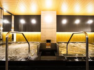 a hot tub in a room with yellow walls at APA Hotel & Resort Osaka Namba Ekimae Tower in Osaka