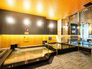 a swimming pool with a glass door in a building at APA Hotel & Resort Osaka Namba Ekimae Tower in Osaka