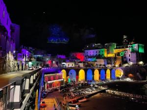 a city lit up at night with a bridge at Blue Atrani Central House - 150 mt dalla spiaggia in Atrani