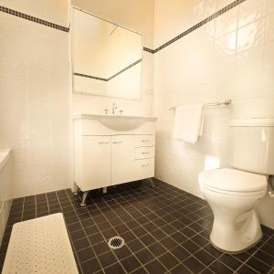Un baño blanco con lavabo e inodoro. en The Regent Guesthouse, en Sídney