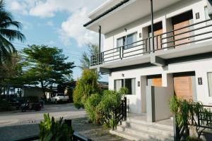 a white house with stairs and trees on a street at Nangkam Boutique House 