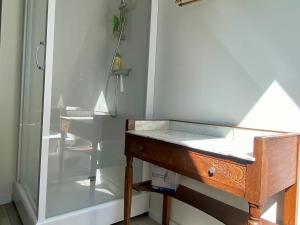 a bathroom with a wooden sink and a shower at Maison cosy à 5 min de la plage de Poulziourec ! - FR-1-813-32 in Groix