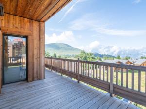 eine Holzterrasse mit Bergblick in der Unterkunft Luxueux Duplex 127m² aux Pistes - Parking Inclus - FR-1-645-86 in Huez