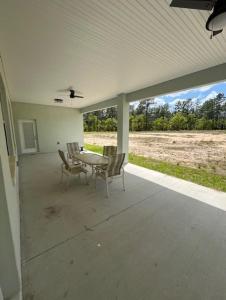 a patio with a table and chairs and a field at Modern & Peaceful Retreat Near WEC & Ocala Amenities in Ocala
