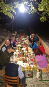 a group of people sitting around a long table at Buni Shqipes in Theth