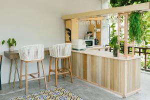 a kitchen with two bar stools and a counter at Nangkam Boutique House 