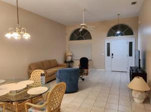 uma sala de estar com um sofá, uma mesa e cadeiras em Work Ready Quite Comfy Bedrooms in Palm Coast Perfect for Mid-Term Stay em Palm Coast