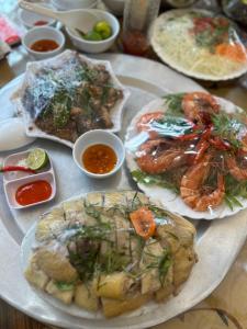 una mesa con platos de comida con camarones y otros alimentos en Nhật Huy 401DM2, en Hanói